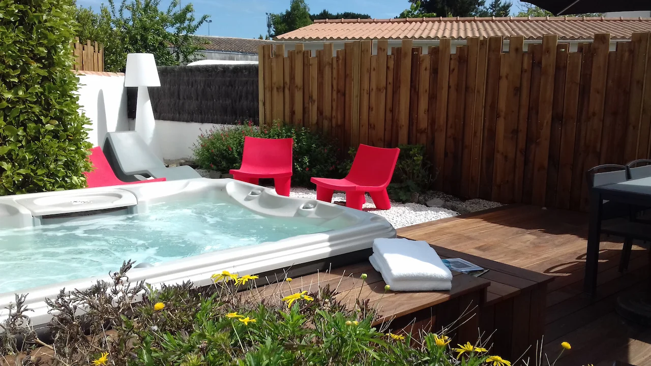Terrasse extérieure en bois avec table et chaises de jardin et jacuzzi
