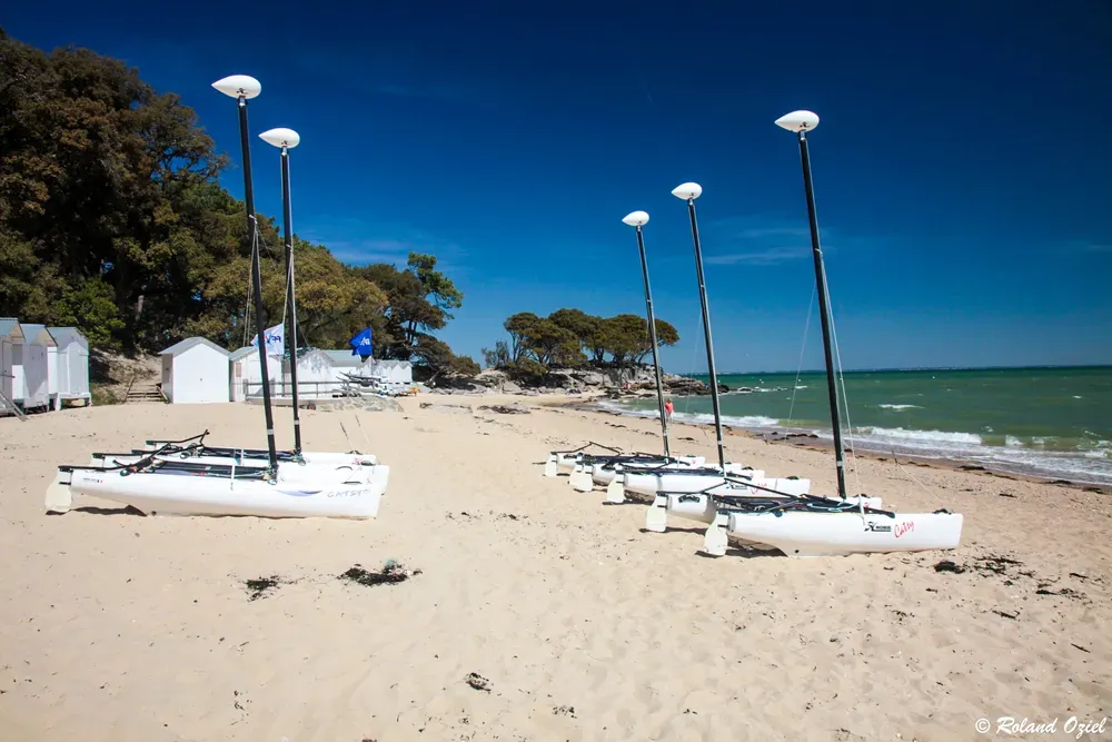 Plage avec catamarans et cabanes typiques